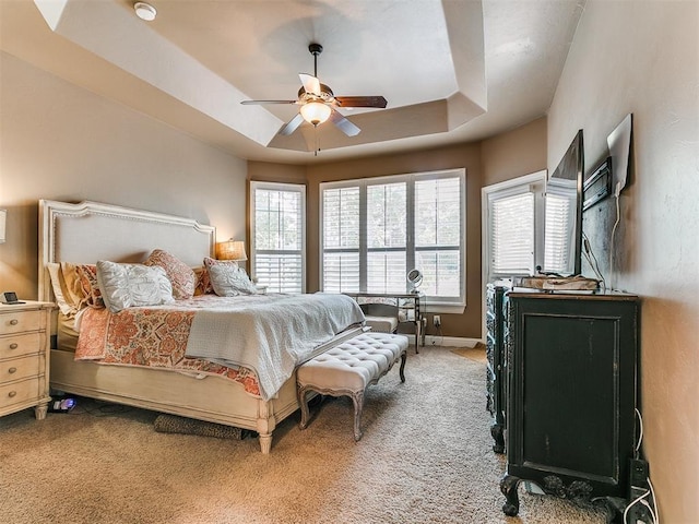 404 Nantucket Blvd, Norman, OK 73071 - bedroom with light colored carpet, a tray ceiling, a ceiling fan, and baseboards