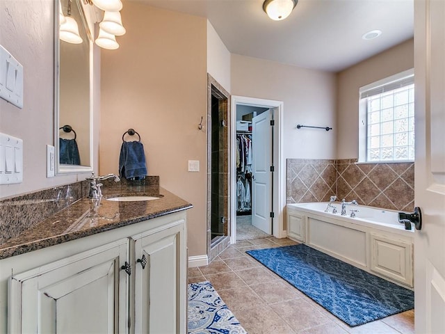 404 Nantucket Blvd, Norman, OK 73071 - bathroom with a garden tub, vanity, tile patterned flooring, a shower stall, and a walk in closet