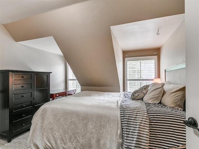 404 Nantucket Blvd, Norman, OK 73071 - bedroom featuring multiple windows, vaulted ceiling, and light colored carpet