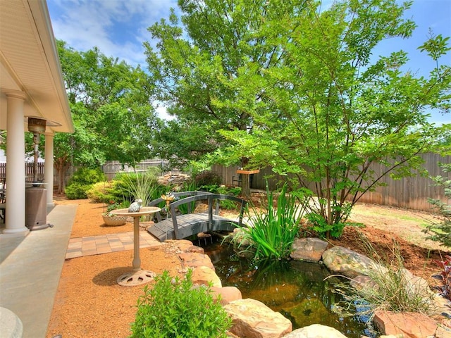 404 Nantucket Blvd, Norman, OK 73071 - fenced backyard featuring a patio area and a garden pond