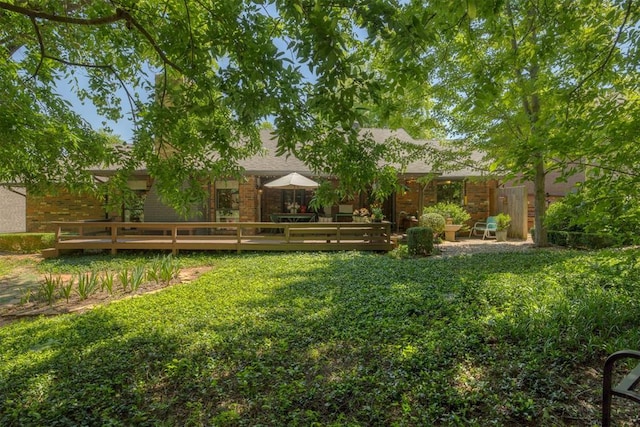 view of green lawn featuring a deck