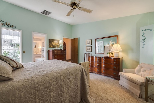bedroom featuring carpet flooring, ensuite bath, and a ceiling fan