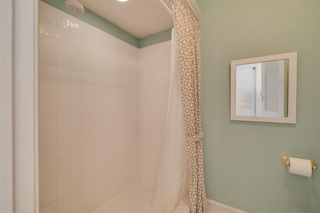 full bathroom featuring a stall shower and baseboards