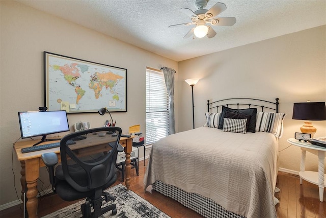 bedroom with baseboards, wood finished floors, a desk, ceiling fan, and a textured ceiling