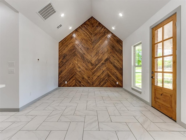 1518 NW 8th St, Oklahoma City, OK 73106 - empty room featuring baseboards, wooden walls, high vaulted ceiling, and recessed lighting