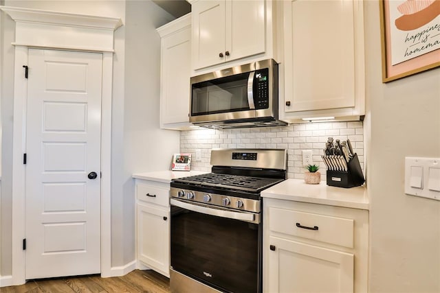 1425 NW 12th St, Newcastle, OK 73065 - kitchen with appliances with stainless steel finishes, light countertops, decorative backsplash, and light wood-style flooring