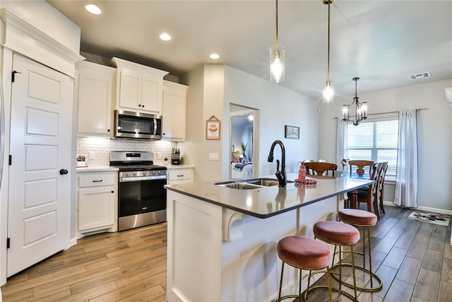 1425 NW 12th St, Newcastle, OK 73065 - kitchen with stainless steel appliances, a sink, light wood finished floors, a breakfast bar area, and recessed lighting
