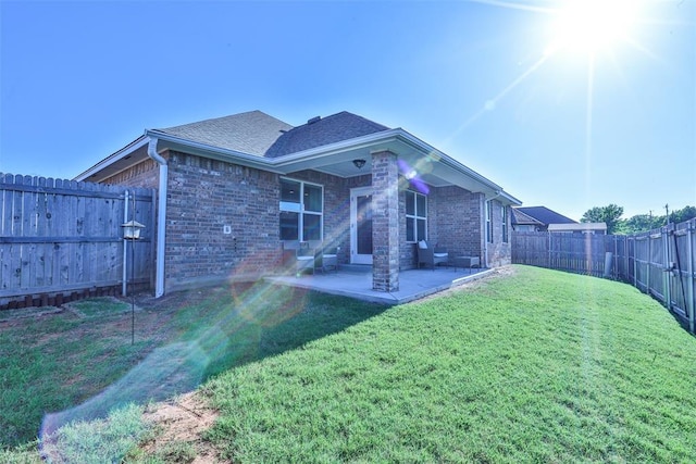 1425 NW 12th St, Newcastle, OK 73065 - back of property with brick siding, a patio area, and a shingled roof