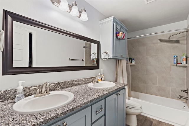 12509 NE 36th Sts, Spencer, OK 73084 - bathroom featuring toilet, bathing tub / shower combination, double vanity, and wood finished floors