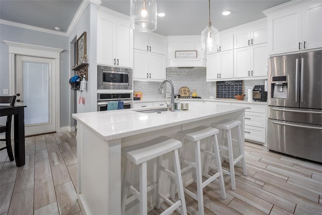14205 Village Creek Way, Piedmont, OK 73078 - kitchen with appliances with stainless steel finishes, a sink, crown molding, wood finish floors, and tasteful backsplash