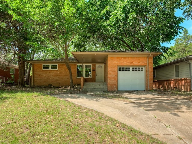 view of front of home featuring an attached garage, brick siding, concrete driveway, and a front yard