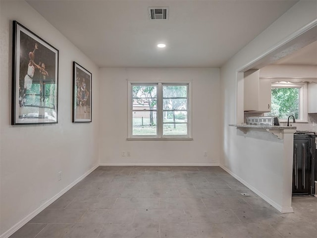 unfurnished dining area with plenty of natural light, baseboards, recessed lighting, and light tile patterned flooring