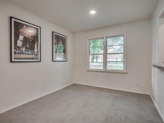 empty room featuring baseboards and recessed lighting