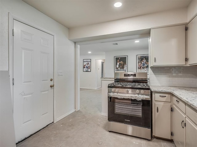 kitchen with gas stove, backsplash, recessed lighting, light stone counters, and baseboards