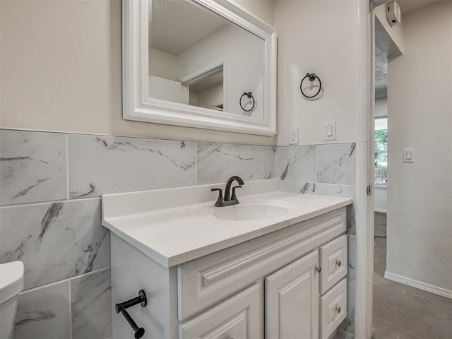 bathroom with tile walls, vanity, and toilet