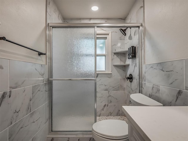 full bath with a shower stall, toilet, tile walls, and vanity