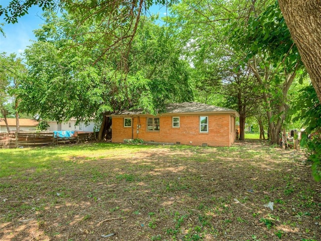 back of property with crawl space and brick siding
