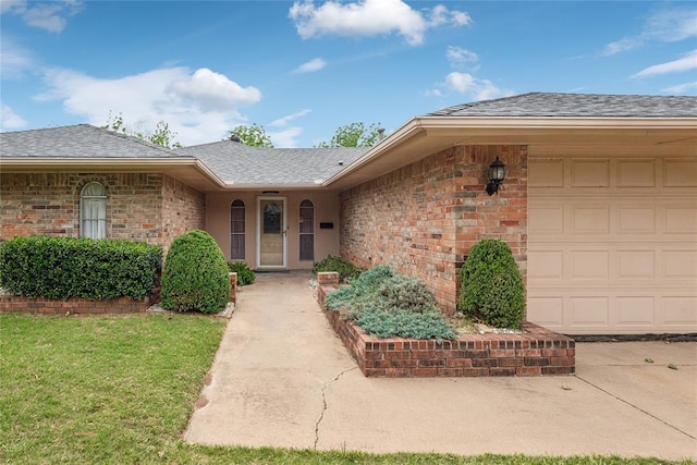 3109 N Glade Ave, Bethany, OK 73008 - view of exterior entry featuring a yard, a garage, brick siding, and a shingled roof
