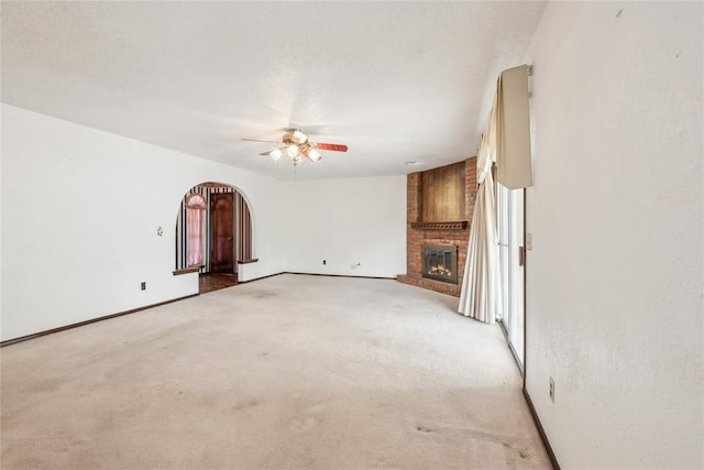 3109 N Glade Ave, Bethany, OK 73008 - unfurnished living room featuring ceiling fan, arched walkways, a fireplace, and baseboards