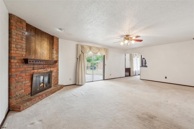 3109 N Glade Ave, Bethany, OK 73008 - unfurnished living room featuring a fireplace, a textured ceiling, a ceiling fan, carpet, and baseboards