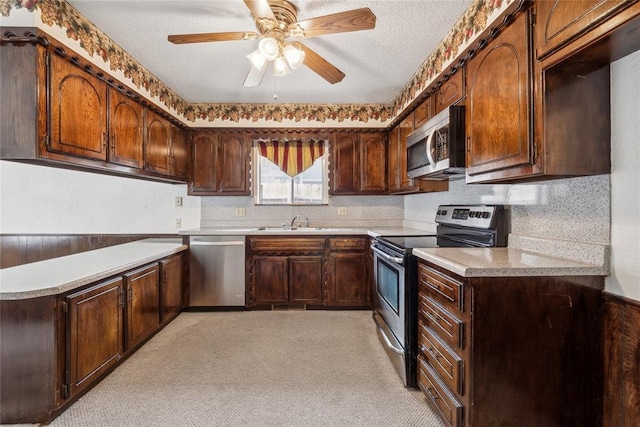 3109 N Glade Ave, Bethany, OK 73008 - kitchen featuring stainless steel appliances, a sink, light colored carpet, light countertops, and ceiling fan