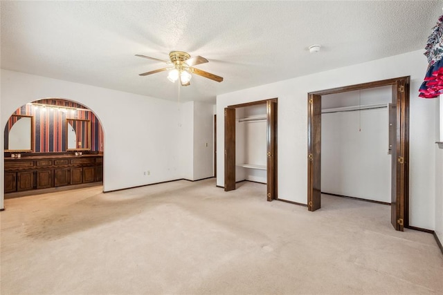 3109 N Glade Ave, Bethany, OK 73008 - unfurnished bedroom featuring two closets, carpet flooring, ceiling fan, baseboards, and connected bathroom