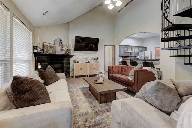 17009 Picasso Dr, Oklahoma City, OK 73170 - living area featuring ceiling fan, arched walkways, a fireplace, high vaulted ceiling, and light wood-style flooring