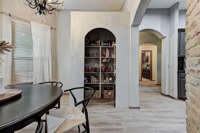 17009 Picasso Dr, Oklahoma City, OK 73170 - dining area with light wood-style floors, a chandelier, and arched walkways