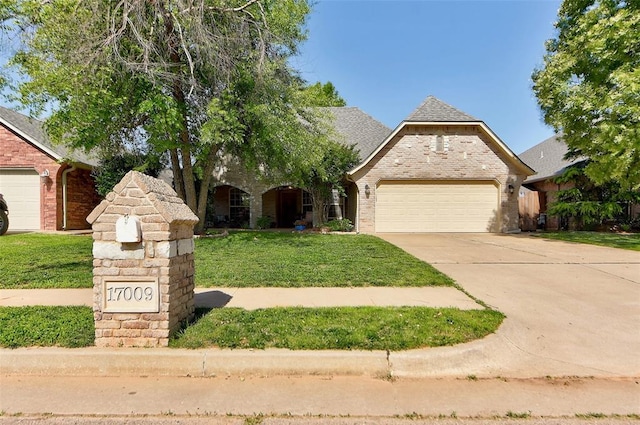 17009 Picasso Dr, Oklahoma City, OK 73170 - view of front of home featuring an attached garage, a front lawn, brick siding, and concrete driveway