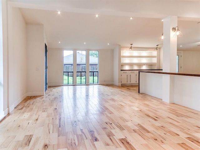 unfurnished living room featuring light wood finished floors, baseboards, and recessed lighting