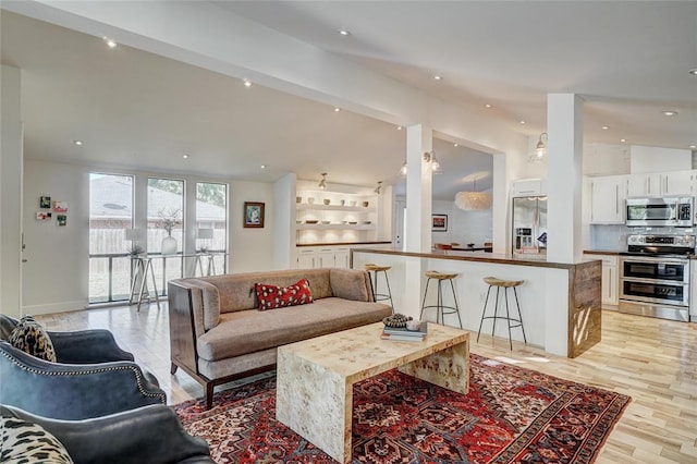 living area with light wood-type flooring, vaulted ceiling, and recessed lighting