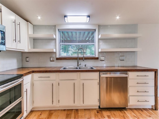 kitchen featuring open shelves, stainless steel appliances, a sink, backsplash, and recessed lighting