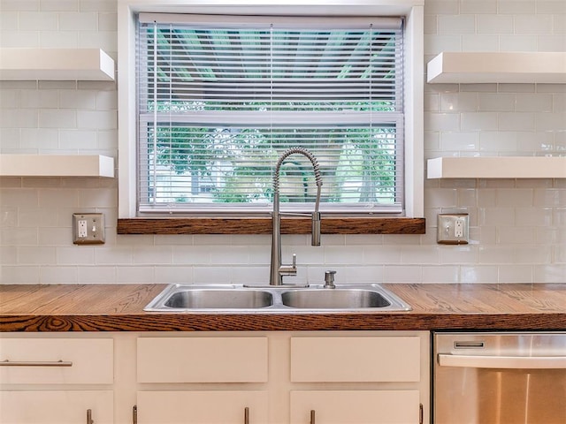 kitchen featuring dishwasher, a sink, and open shelves