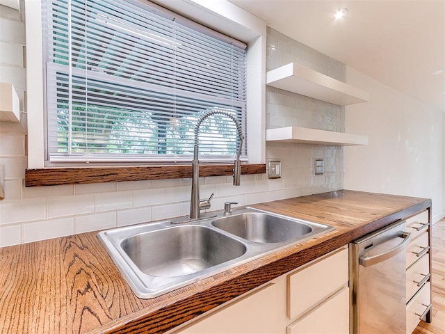 kitchen featuring a sink, dishwasher, open shelves, backsplash, and healthy amount of natural light