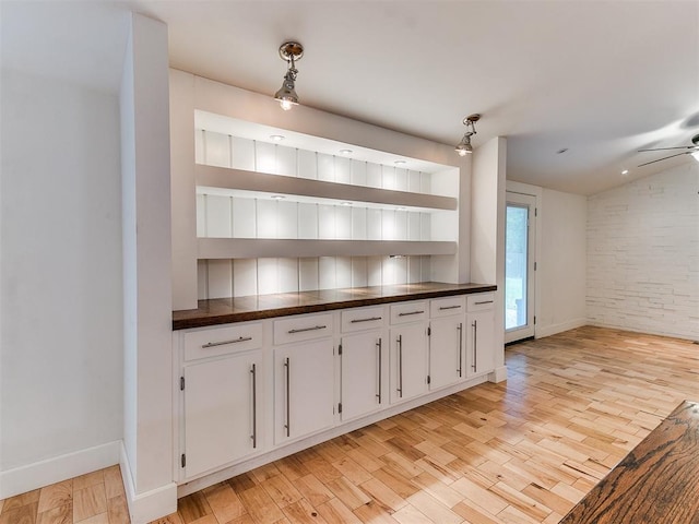 bar featuring light wood-style flooring, baseboards, and ceiling fan