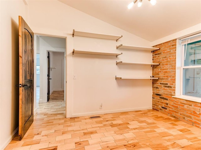 spare room with vaulted ceiling, baseboards, and plenty of natural light
