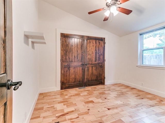 unfurnished bedroom featuring vaulted ceiling, baseboards, and a ceiling fan