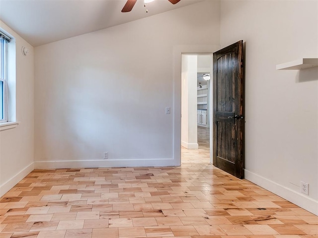 unfurnished room featuring a ceiling fan, baseboards, and light wood-type flooring