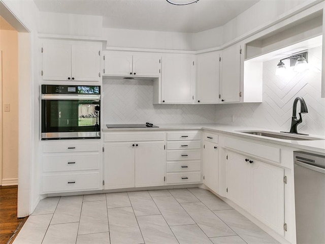 213 E Haddock St, Norman, OK 73069 - kitchen with appliances with stainless steel finishes, a sink, decorative backsplash, and light countertops