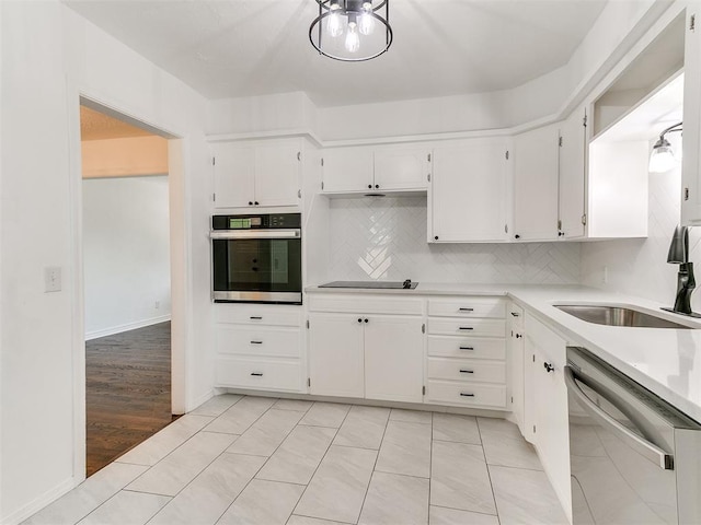 213 E Haddock St, Norman, OK 73069 - kitchen with stainless steel appliances, a sink, light countertops, decorative backsplash, and white cabinets
