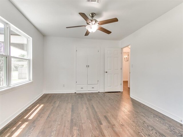 213 E Haddock St, Norman, OK 73069 - unfurnished bedroom featuring baseboards, wood finished floors, ceiling fan, and a closet