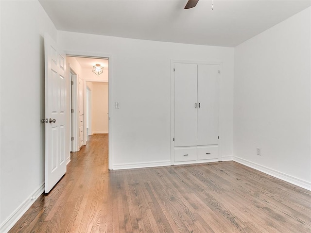 213 E Haddock St, Norman, OK 73069 - unfurnished bedroom with wood finished floors, baseboards, a ceiling fan, and a closet