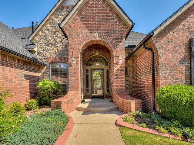 12515 Forest Oaks Dr, Choctaw, OK 73020 - view of exterior entry with brick siding and a shingled roof