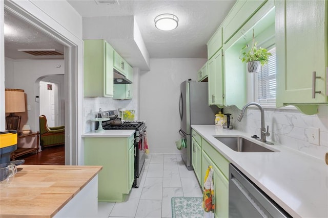 2017 NE 20th St, Oklahoma City, OK 73111 - kitchen with green cabinets, appliances with stainless steel finishes, a sink, and under cabinet range hood