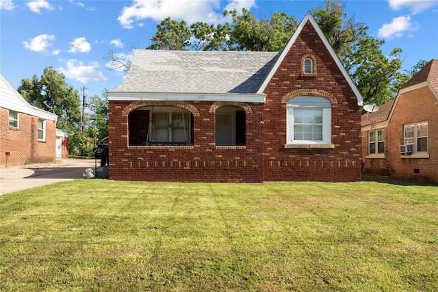 2017 NE 20th St, Oklahoma City, OK 73111 - tudor-style house featuring brick siding, roof with shingles, a front yard, and cooling unit