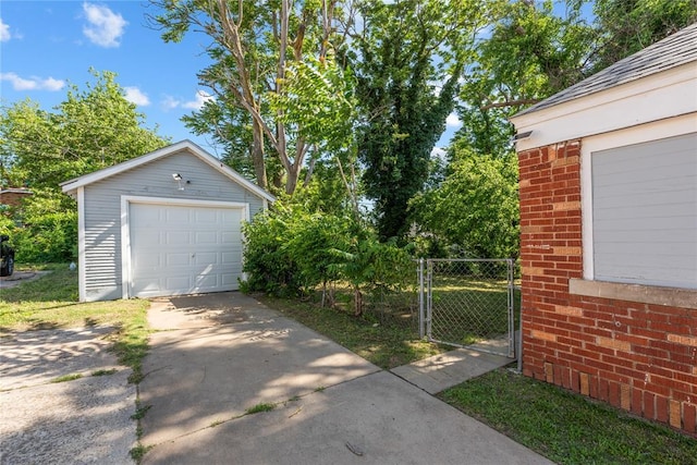 2017 NE 20th St, Oklahoma City, OK 73111 - detached garage featuring concrete driveway, fence, and a gate