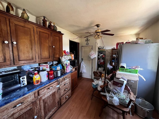 6616 SW 134th St, Oklahoma City, OK 73173 - kitchen featuring dark wood-style floors, ceiling fan, dark countertops, and freestanding refrigerator