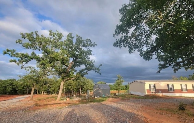 view of dirt / gravel driveway featuring an exterior structure