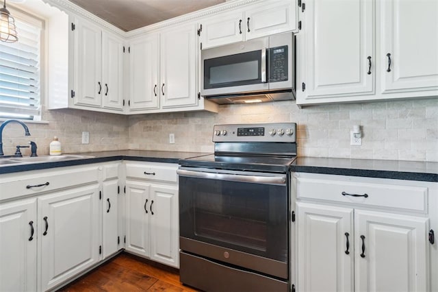 1500 S Railroad, Marlow, OK 73055 - kitchen featuring stainless steel appliances, a sink, dark countertops, white cabinets, and dark wood-style floors