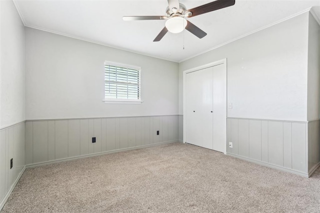 1500 S Railroad, Marlow, OK 73055 - unfurnished bedroom with carpet, a wainscoted wall, a closet, crown molding, and a ceiling fan
